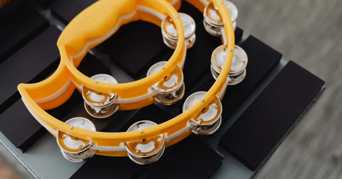 Tambourin jaune vif reposant sur un clavier noir. Parfait pour des thèmes liés à la musique.