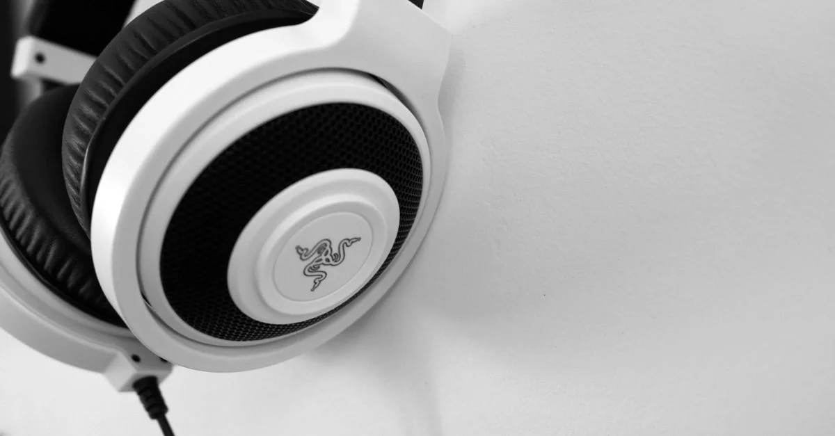 Gros plan sur des écouteurs blancs élégants sur fond minimaliste, parfaits pour les passionnés de technologie.