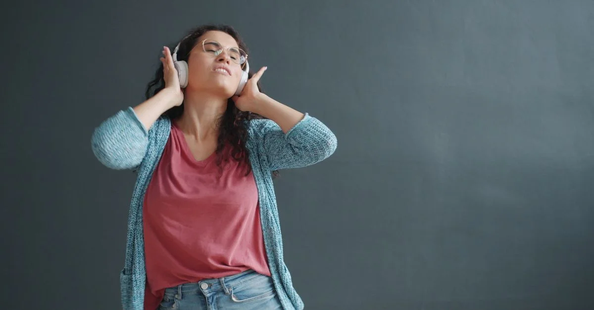 Une femme trouve joie et relaxation en écoutant de la musique avec des casques.