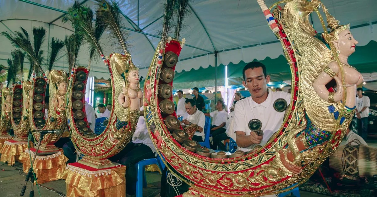 Des musiciens jouent des instruments traditionnels d'Asie du Sud-Est dans un espace intérieur sous une tente.