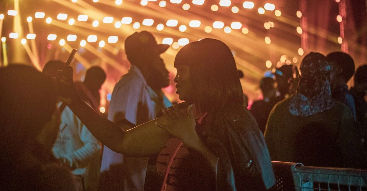 Foule énergique profitant d'un événement nocturne animé avec des éclairages vibrants.