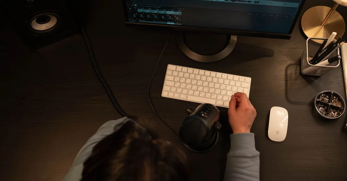 Vue du dessus d'un ingénieur du son travaillant sur un projet d'enregistrement avec des périphériques informatiques dans un studio.