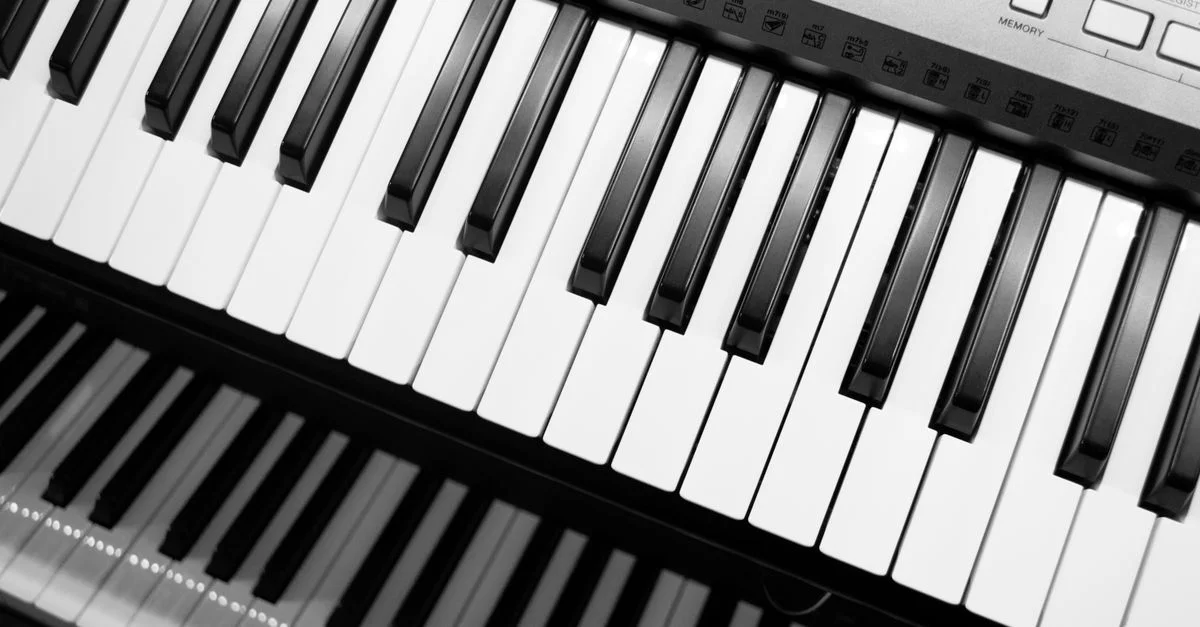 Gros plan d'un clavier électronique noir et blanc, mettant en avant ses touches musicales.