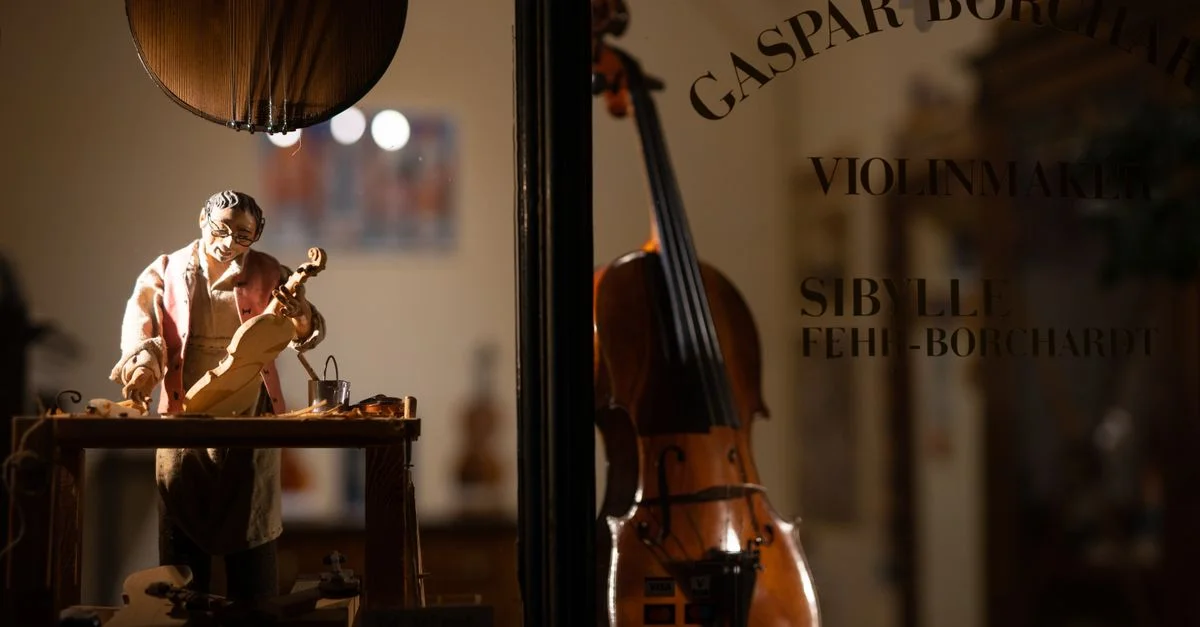 Gros plan de l'atelier d'un luthier avec une figurine et des instruments à Crémone, en Italie.