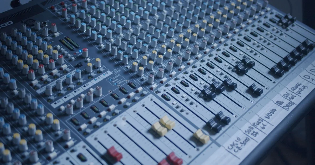Vue détaillée d'un mélangeur audio professionnel dans un cadre de studio d'enregistrement.