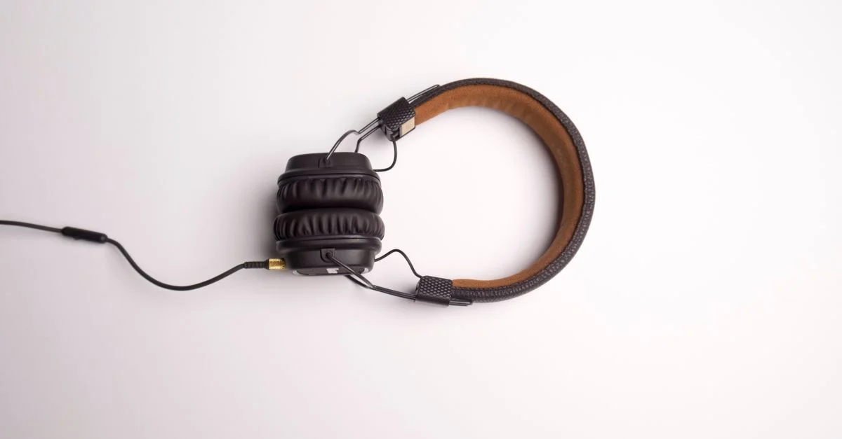 Image minimaliste d'un casque audio noir supra-auriculaire sur fond blanc.