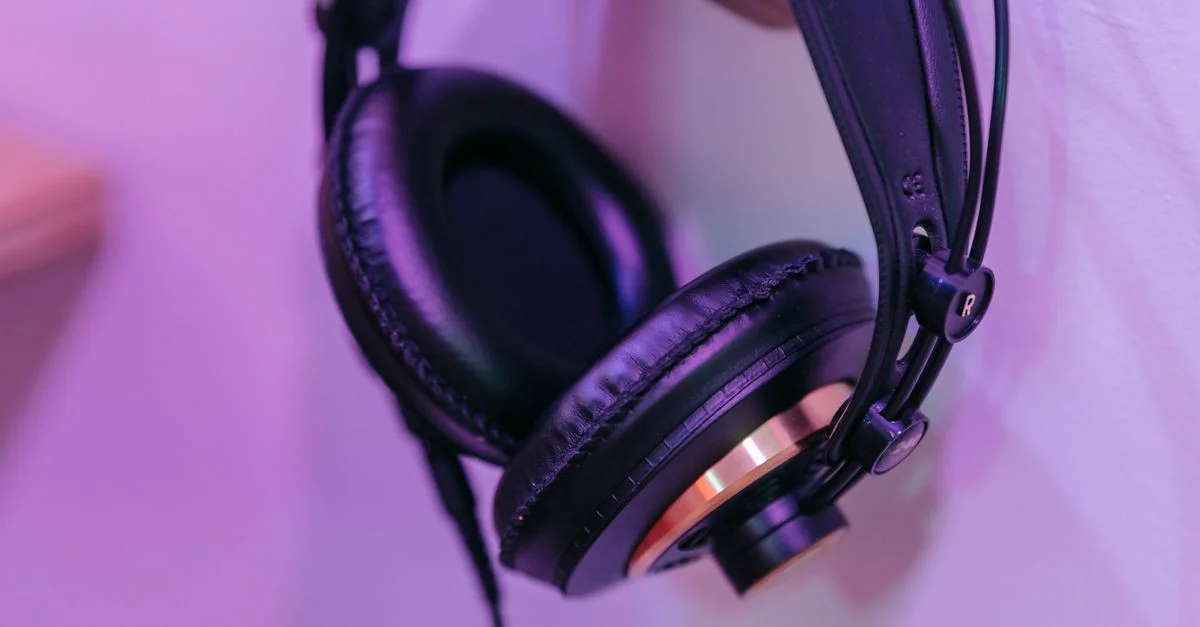 Gros plan élégant de casques noirs suspendus à un crochet sur un fond violet.