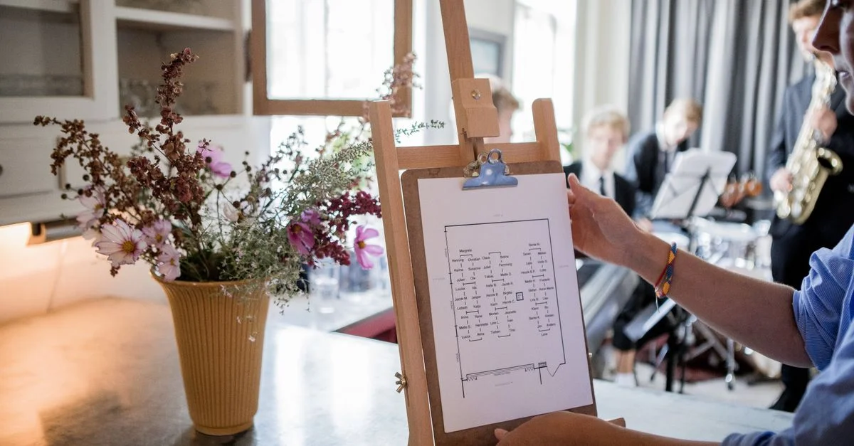 Des musiciens répétant à l'intérieur avec un chevalet affichant un graphique et une décoration florale créant une ambiance artistique.