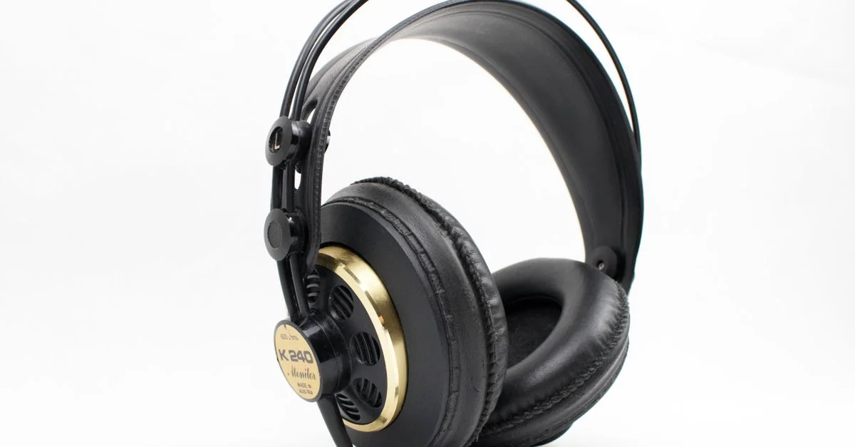 Casque de studio noir et or de haute qualité avec un rembourrage épais sur fond blanc, idéal pour les professionnels de la musique.