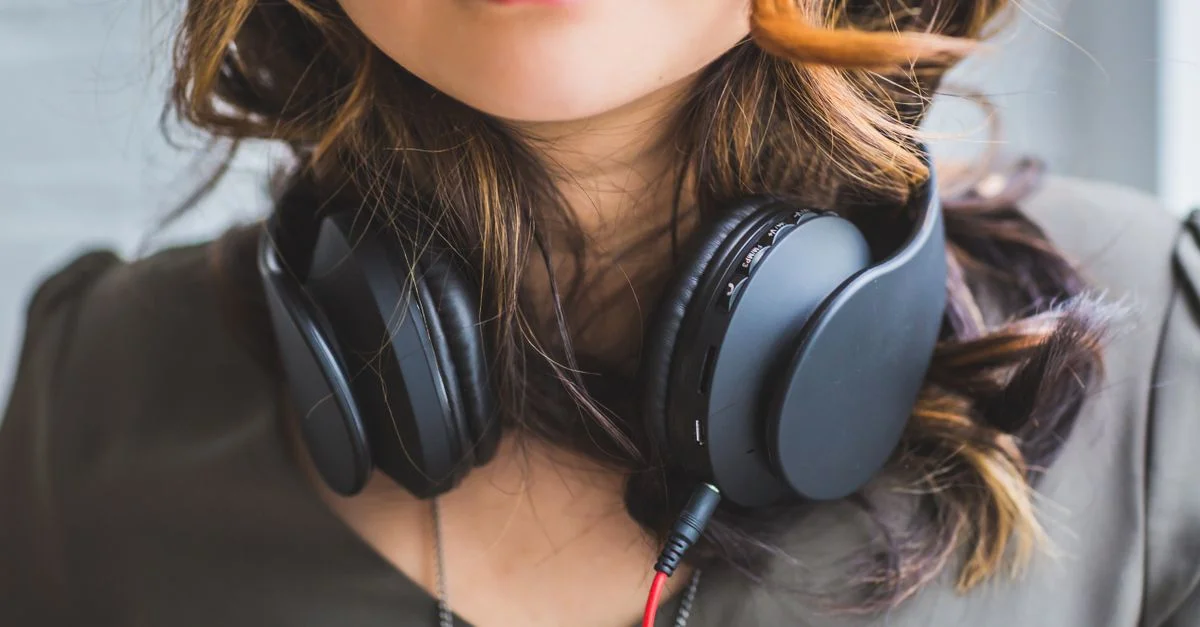 Gros plan élégant d'une femme avec des écouteurs autour du cou, mettant en valeur la mode musicale moderne.