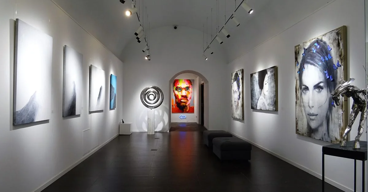 Galerie d'art moderne et épurée avec diverses peintures contemporaines en exposition.