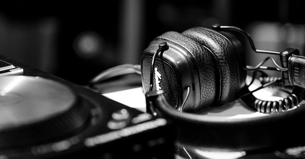 Gros plan sur des écouteurs de DJ et une platine dans un studio, mettant en avant du matériel moderne de musique.