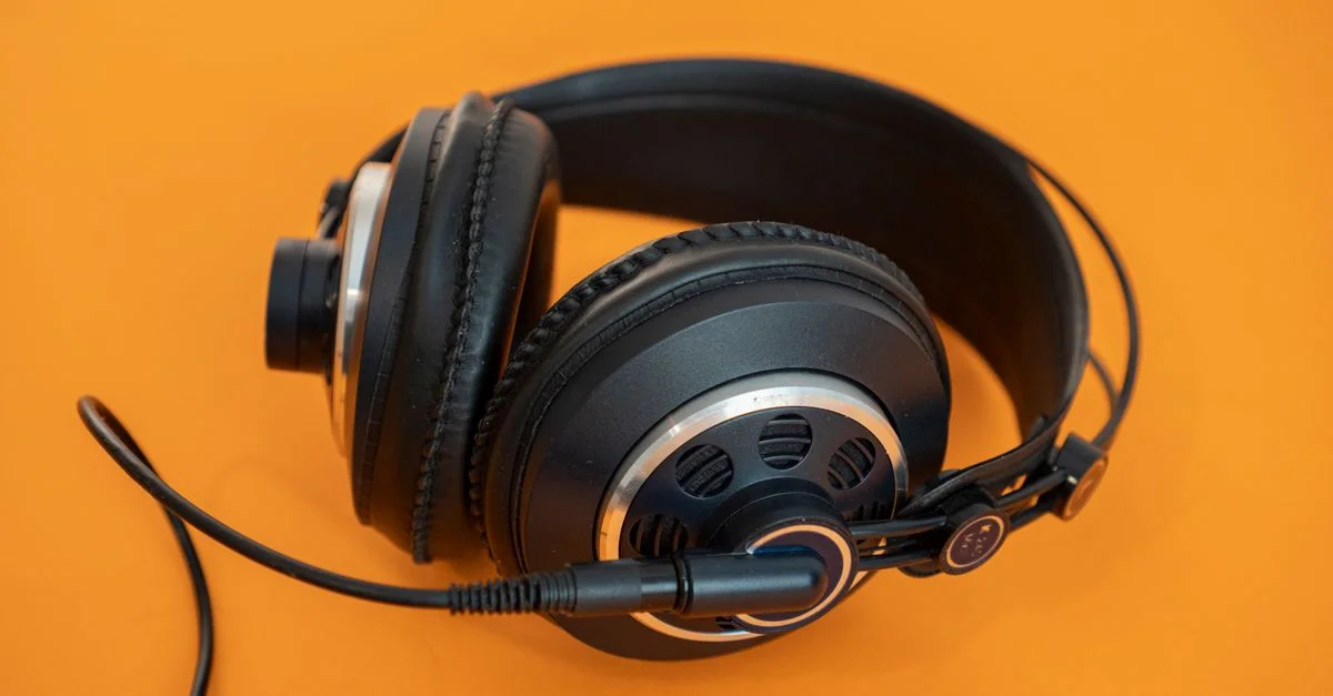 Gros plan sur des casques professionnels sur un fond orange vif, idéal pour des concepts audio et technologiques.
