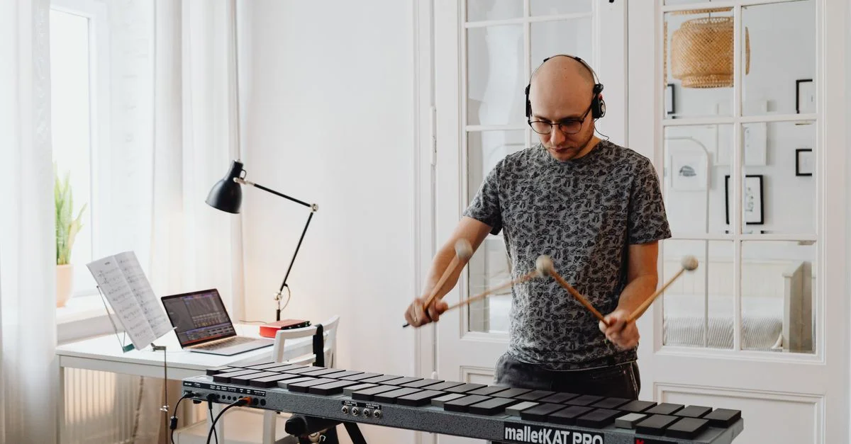 Musicien jouant de l'instrument de percussion électronique MalletKAT dans un studio à la maison élégant.