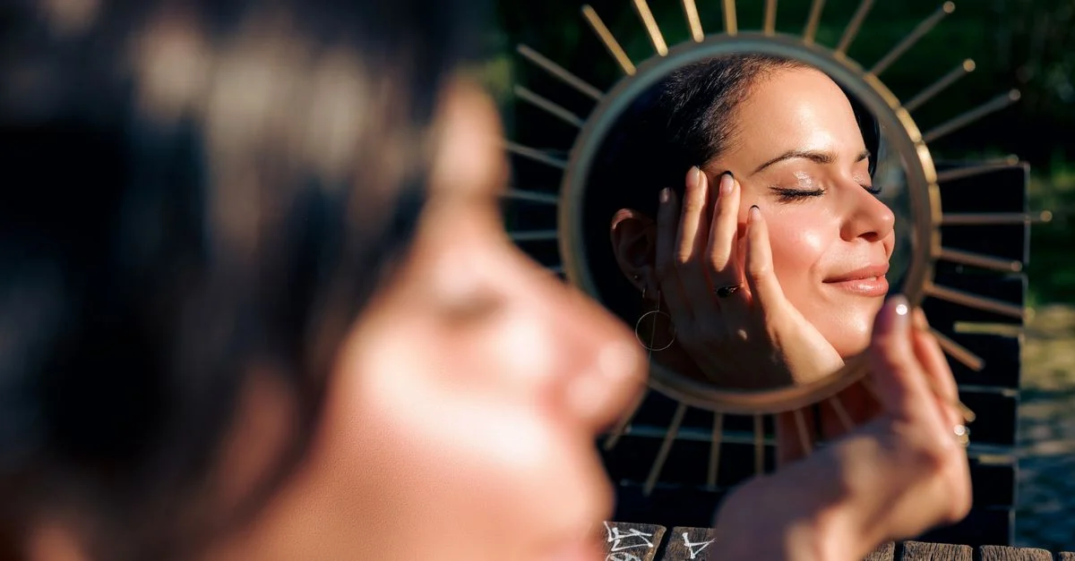 Une femme sereine sourit à son reflet dans un miroir décoratif en plein air à Lisbonne.