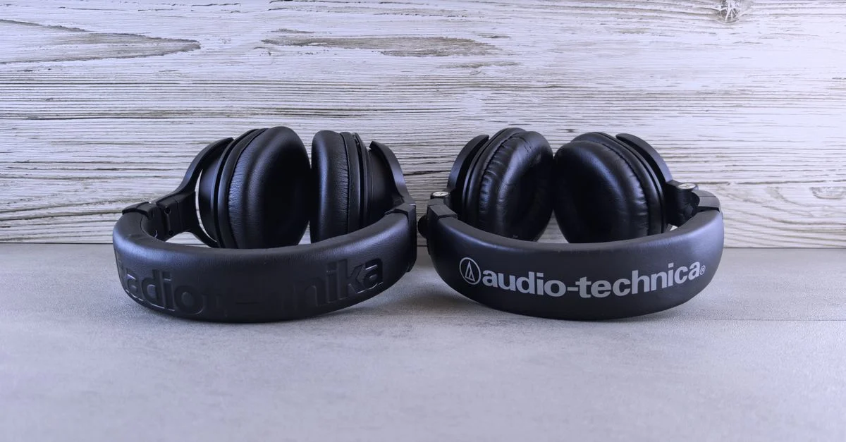 Paire d'écouteurs Audio-Technica présentée sur un fond en bois texturé.