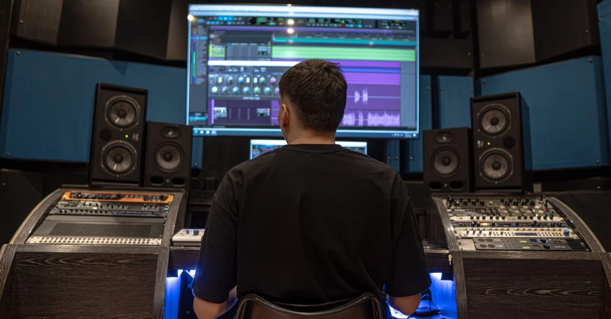 Un homme se concentre sur le montage audio dans un studio d'enregistrement professionnel à Medellín.