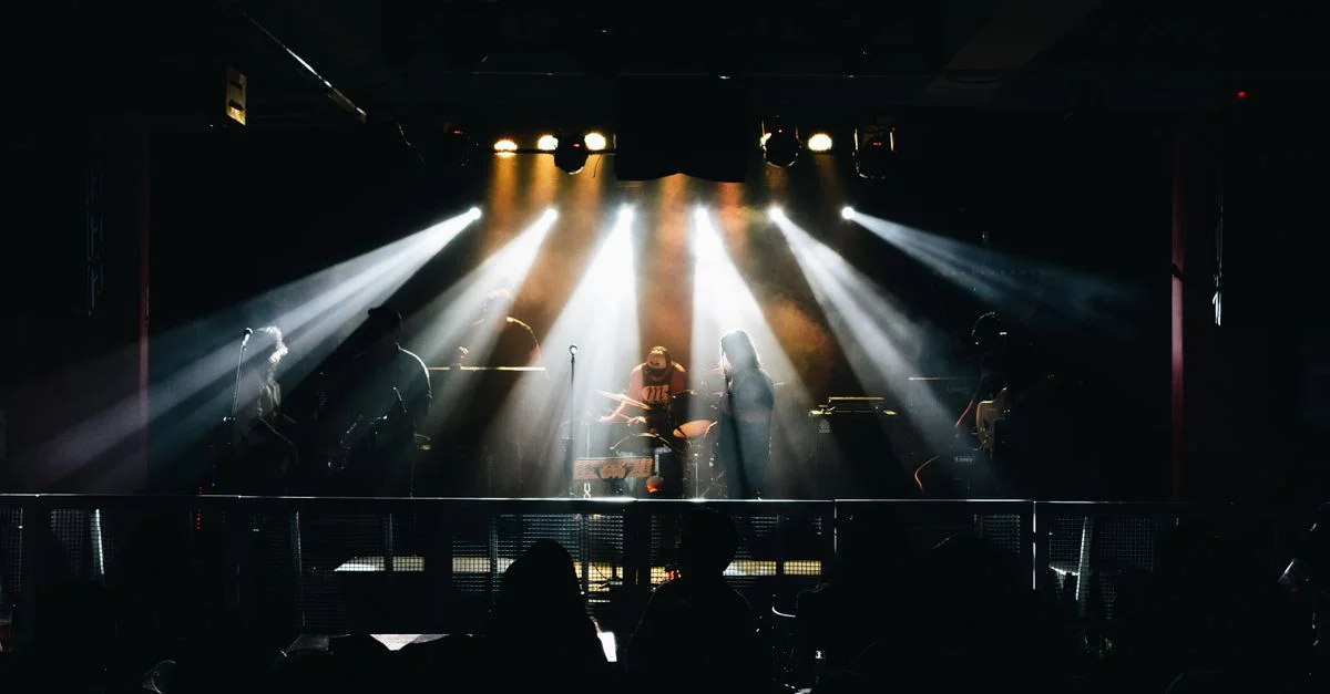 Un concert de musique live vibrant à Lima, au Pérou, mettant en vedette des musiciens sur scène avec un éclairage dramatique.