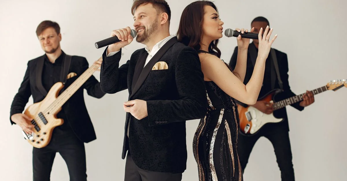 Un groupe élégant se produisant sur scène avec des chanteurs et des musiciens capturés dans des poses dynamiques.