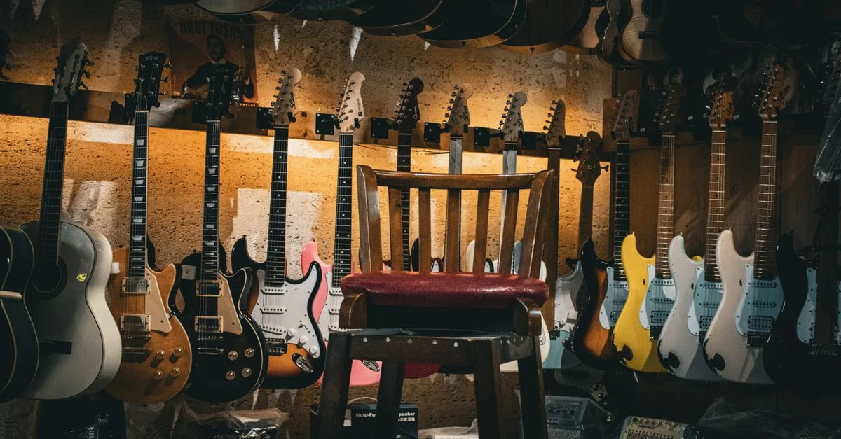 Un magasin de musique chaleureux présentant une variété de guitares et une simple chaise au centre.